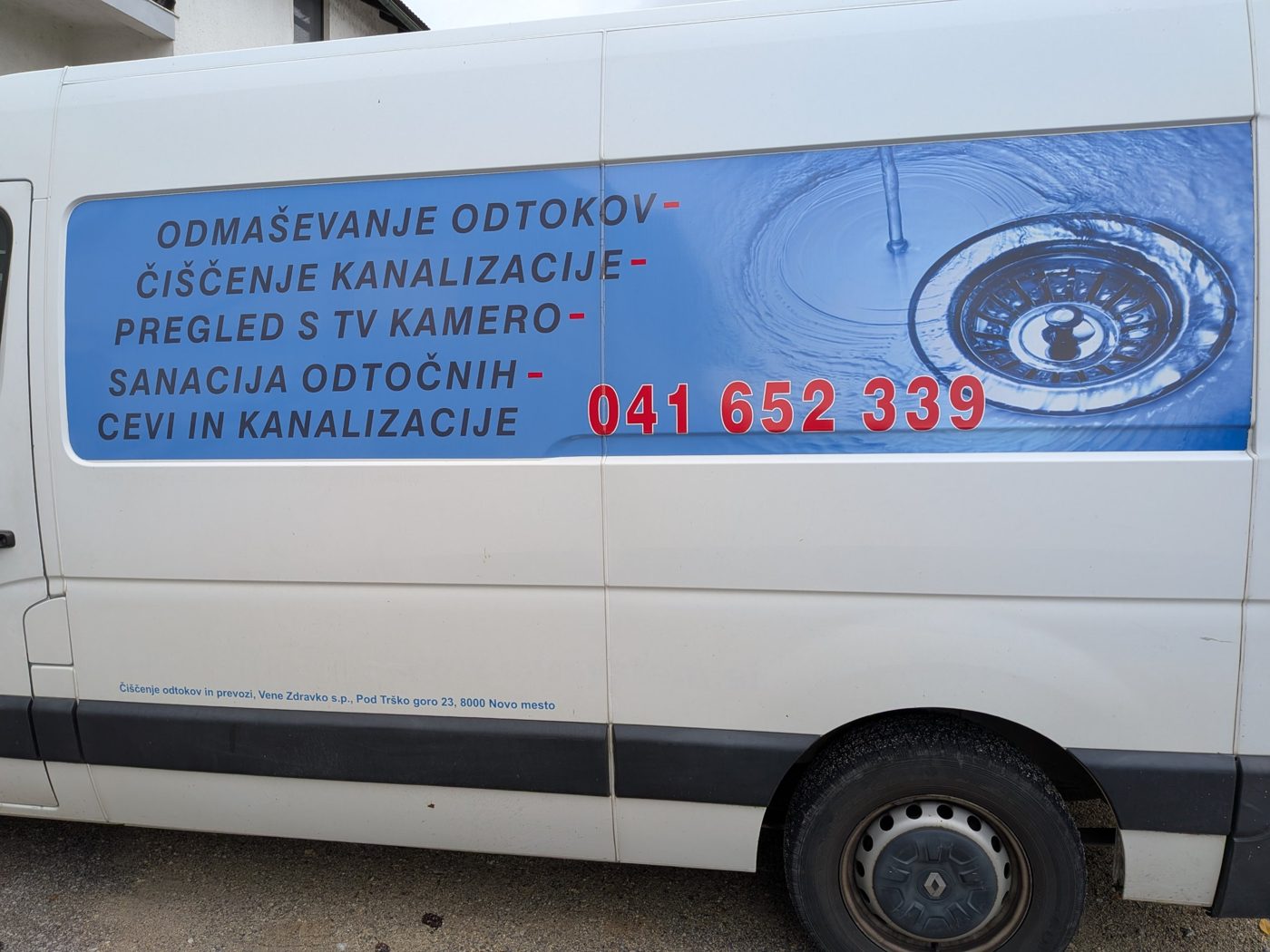 Bočna stran kombija z napisom storitev in podatki podjetja